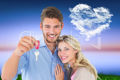 Composite image of attractive young couple showing new house key