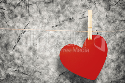 Composite image of heart hanging on line