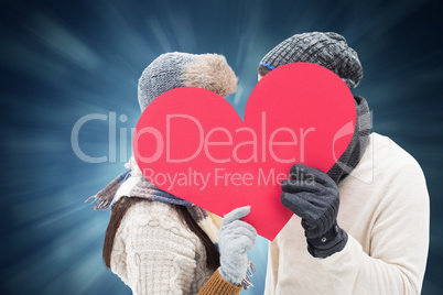 Composite image of attractive young couple in warm clothes holdi