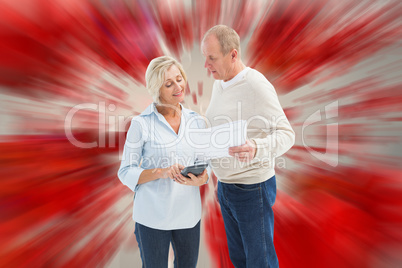 Composite image of mature couple working out their bills