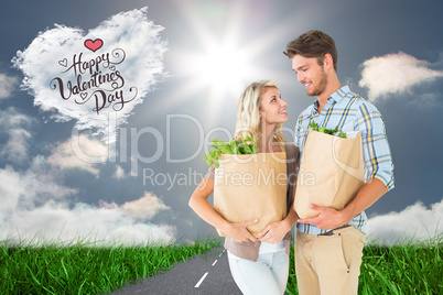 Composite image of attractive couple holding their grocery bags