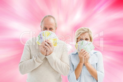 Composite image of happy mature couple smiling at camera showing