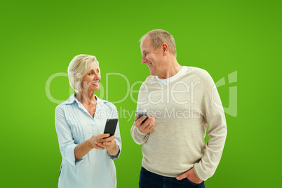 Composite image of happy mature couple using their smartphones