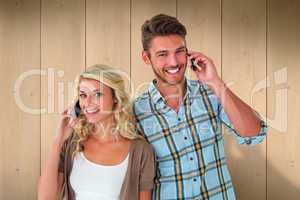 Composite image of attractive couple talking on their smartphone