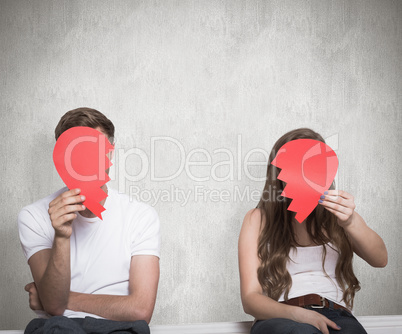 Composite image of couple holding broken heart
