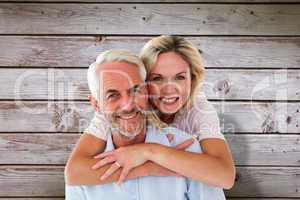 Composite image of smiling couple embracing and looking at camer