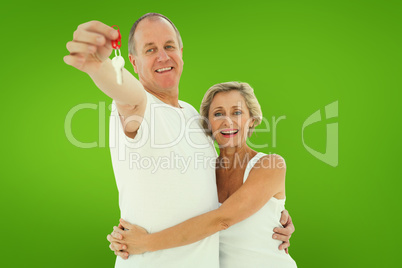 Composite image of mature couple smiling at camera with new hous