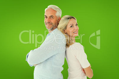 Composite image of smiling couple standing leaning backs togethe