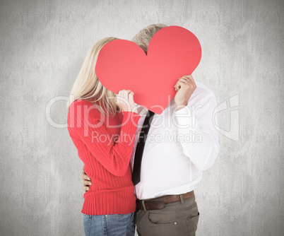 Composite image of handsome man getting a heart card form wife