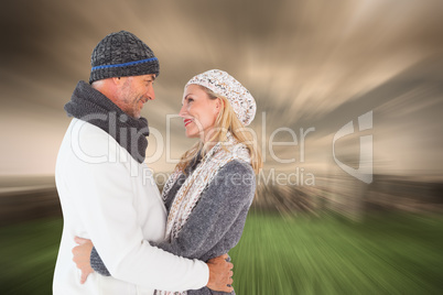 Composite image of happy couple in winter fashion embracing