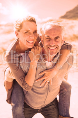 Laughing couple smiling at camera on the beach