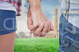 Composite image of couple in check shirts and denim holding hand