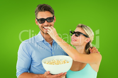 Composite image of happy young couple wearing 3d glasses eating