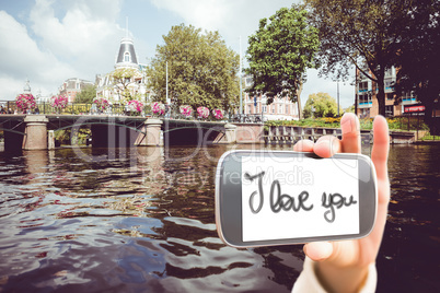 Composite image of hand holding smartphone showing