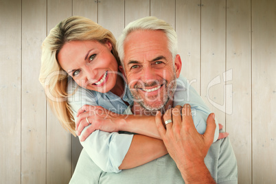 Composite image of happy couple standing and hugging