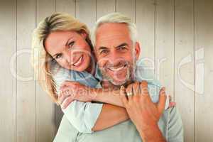 Composite image of happy couple standing and hugging