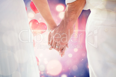 Composite image of bride and groom holding hands close up