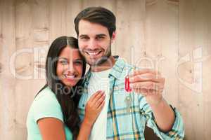 Composite image of happy young couple holding new house key