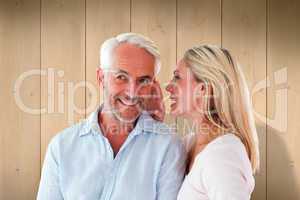 Composite image of woman whispering a secret to husband