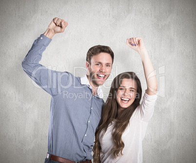 Composite image of happy young couple cheering