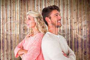 Composite image of attractive couple smiling with arms crossed