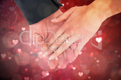 Composite image of close-up of bride and groom with hands togeth