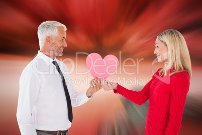 Composite image of handsome man getting a heart card form wife