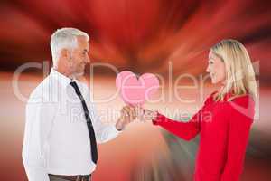 Composite image of handsome man getting a heart card form wife