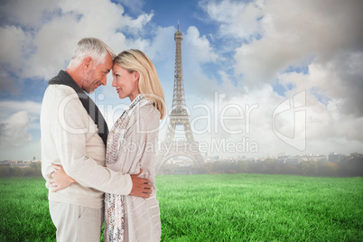 Composite image of happy couple standing and hugging