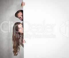 Composite image of portrait of young couple with blank board