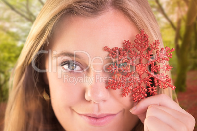 Composite image of festive blonde holding a snowflake