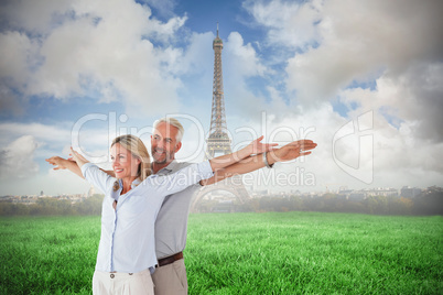 Composite image of happy couple standing with arms outstretched