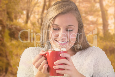 Composite image of pretty blonde enjoying hot chocolate on the c