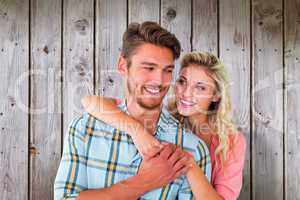 Composite image of attractive couple embracing and smiling