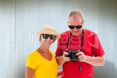 Composite image of happy mature couple wearing sunglasses