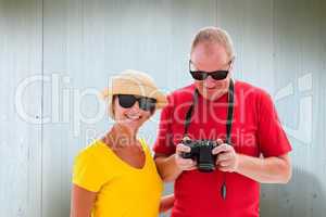 Composite image of happy mature couple wearing sunglasses