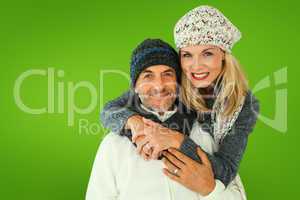 Composite image of happy couple in winter fashion embracing