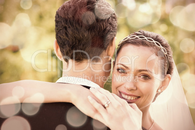 Portrait of happy bride embracing groom