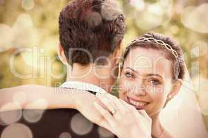 Portrait of happy bride embracing groom