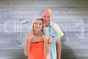 Composite image of happy older couple holding paint roller