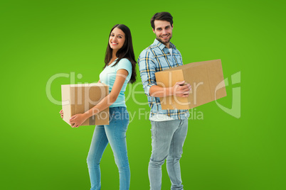 Composite image of happy young couple with moving boxes