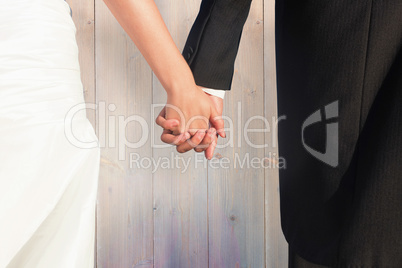 Composite image of close up of cute young newlyweds holding thei