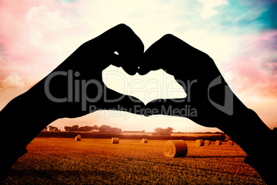 Composite image of woman making heart shape with hands