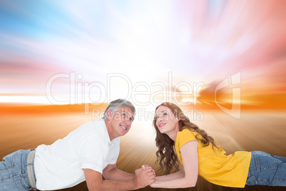 Composite image of casual couple lying and looking up