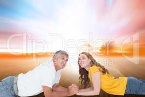 Composite image of casual couple lying and looking up