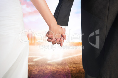 Composite image of close up of cute young newlyweds holding thei