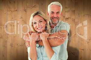 Composite image of happy couple standing and hugging