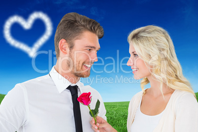 Composite image of handsome man smiling at girlfriend holding a