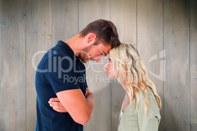 Composite image of young couple standing head to head