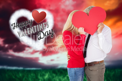 Composite image of handsome man getting a heart card form wife